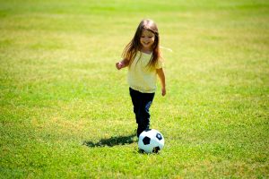 niña pequeña jugando al fútbol para ser profesional