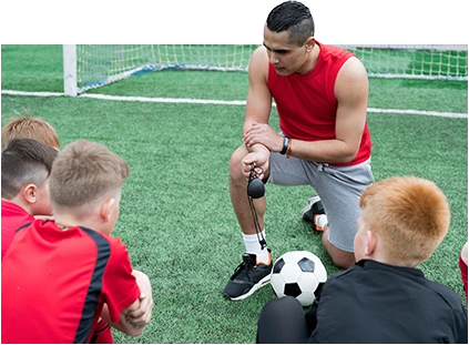 allenatore che insegna ai bambini come giocare a calcio